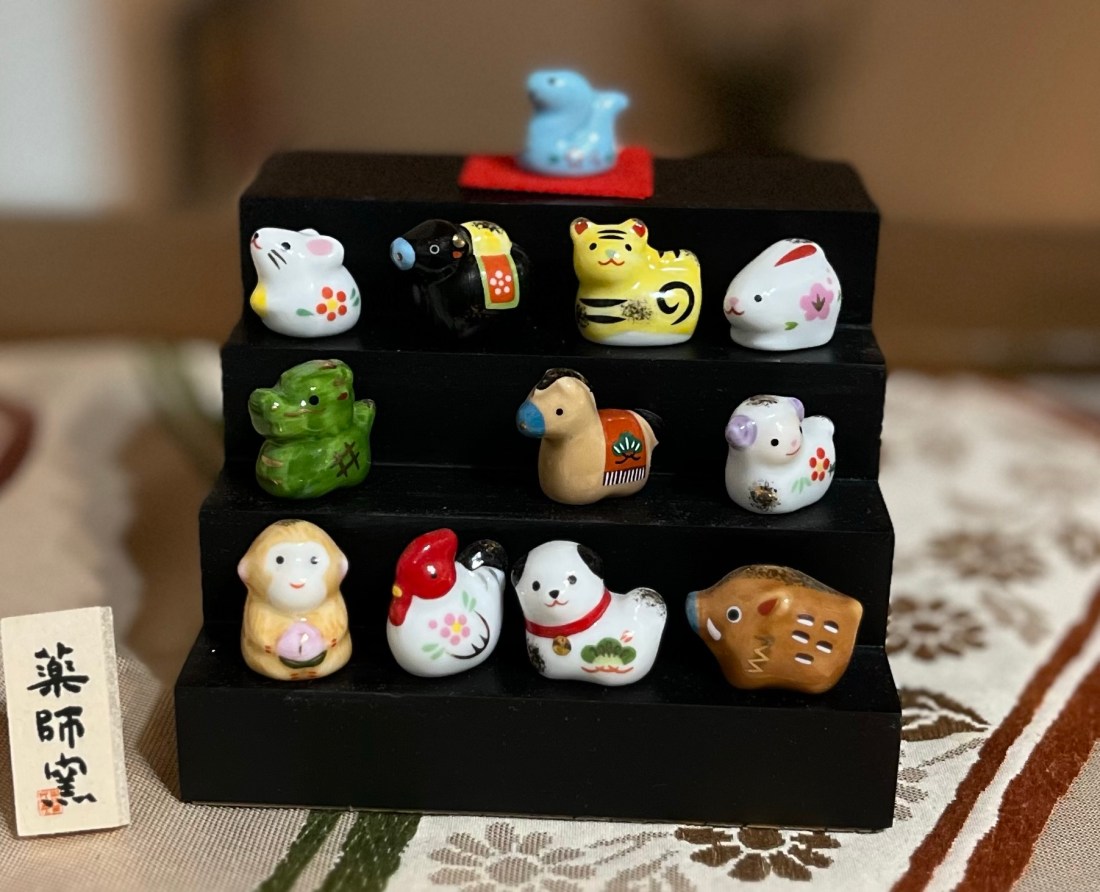 A display of 12 tiny figurines, one for each animal of the Chinese-Japanese zodiac. Includes a snake, dragon, rabbit, ram, etc.